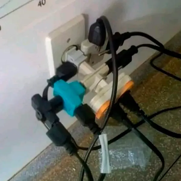 Tomada sobrecarregada com vários plugues e adaptadores ligados ao mesmo ponto